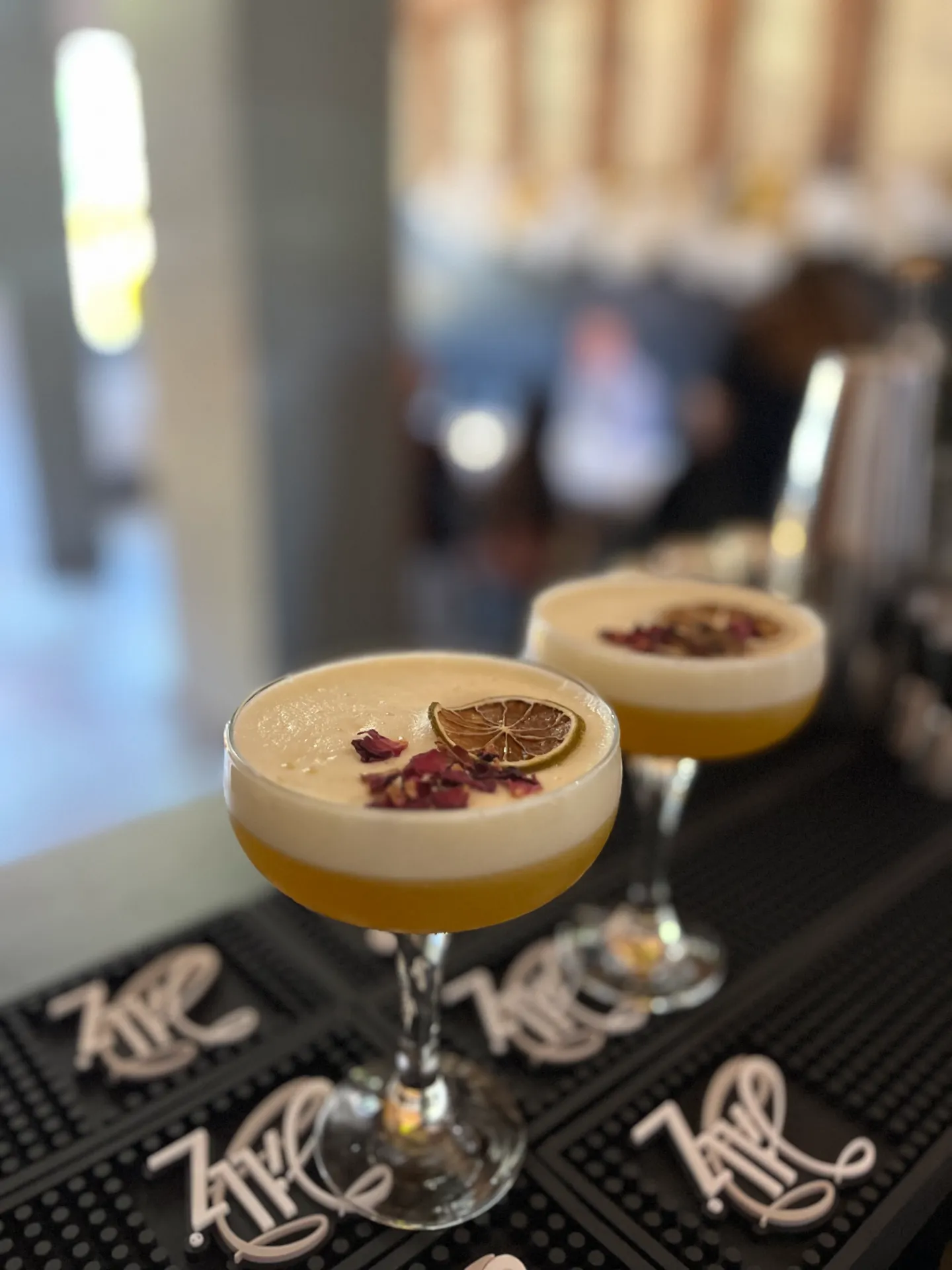 Koktajle sour z płatkami róży w kieliszkach coupe